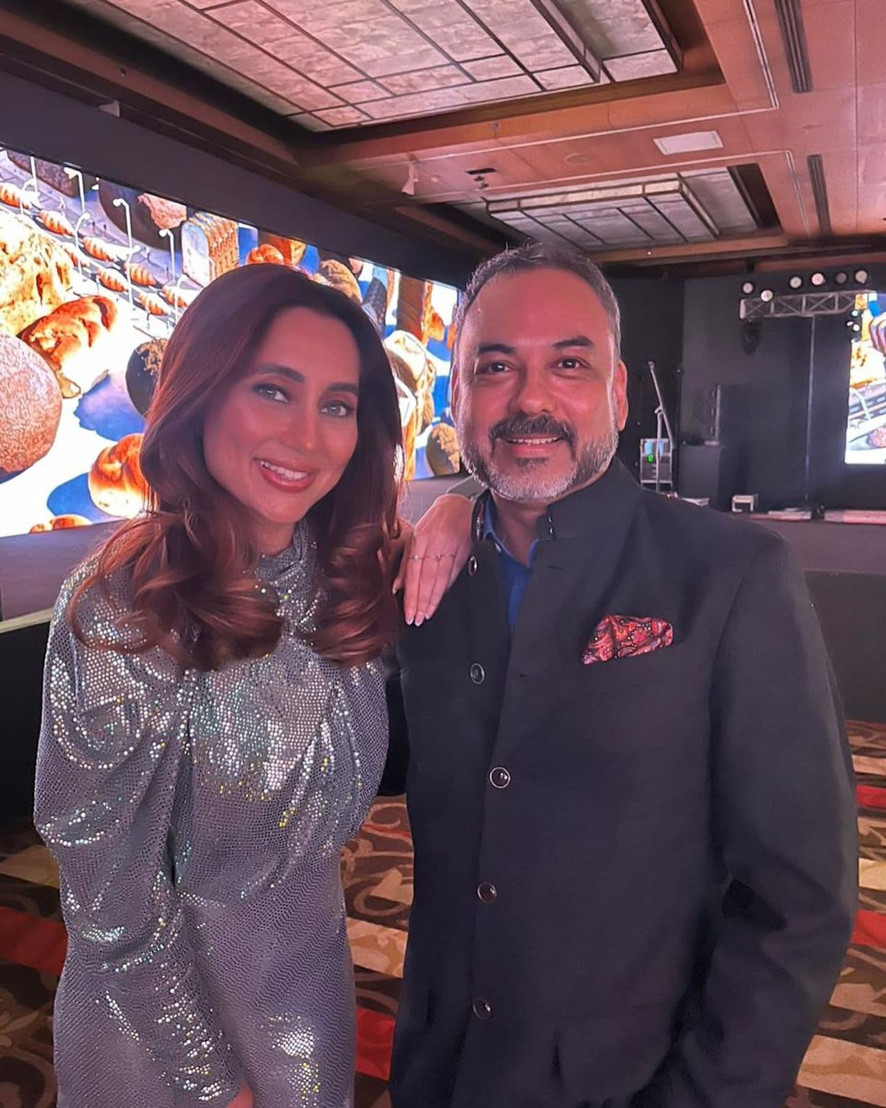 Haute Services founder Maneesh Baheti pictured with a celebrity at an elegant evening event featuring digital displays and sophisticated event space